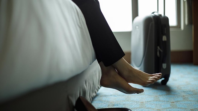 Person relaxing on bed in hotel room